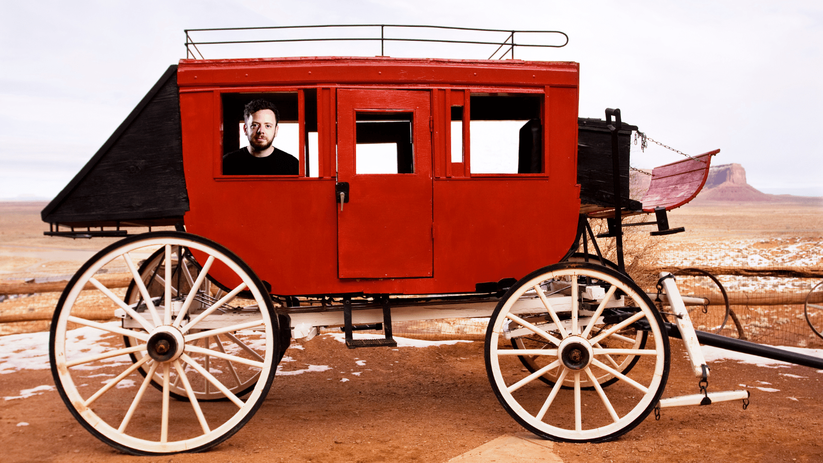 Benefits of Slowing Down - A Picture of Andy Mort in the back of a red stagecoach.